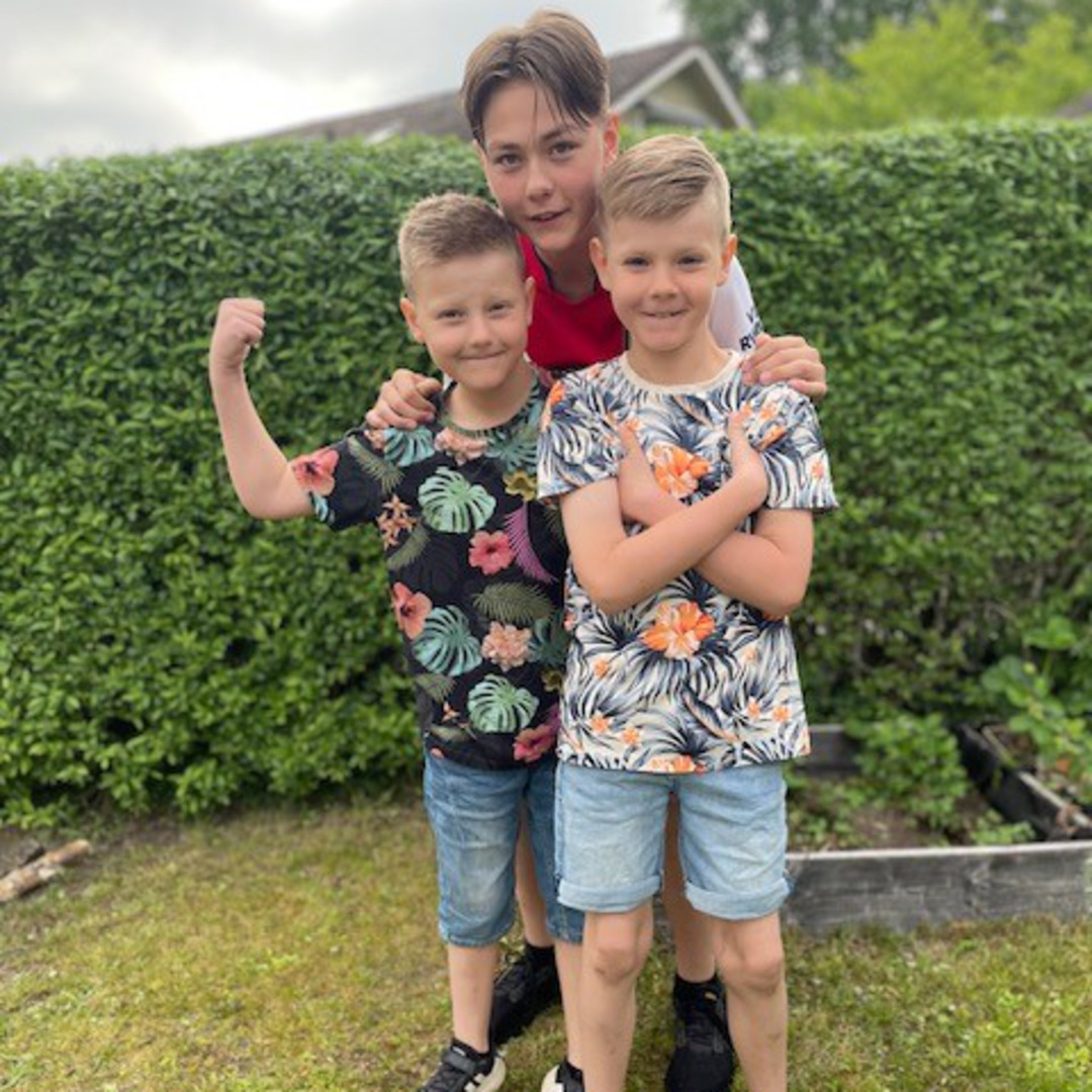 Dom tre br&ouml;derna st&aring;r t&auml;tt tillsammans i en tr&auml;dg&aring;rd.