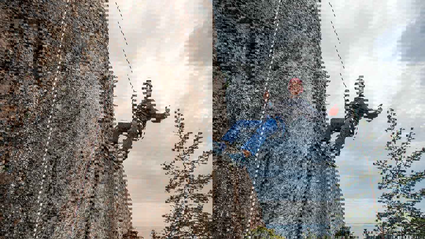 Pojke klättrar på bergsvägg